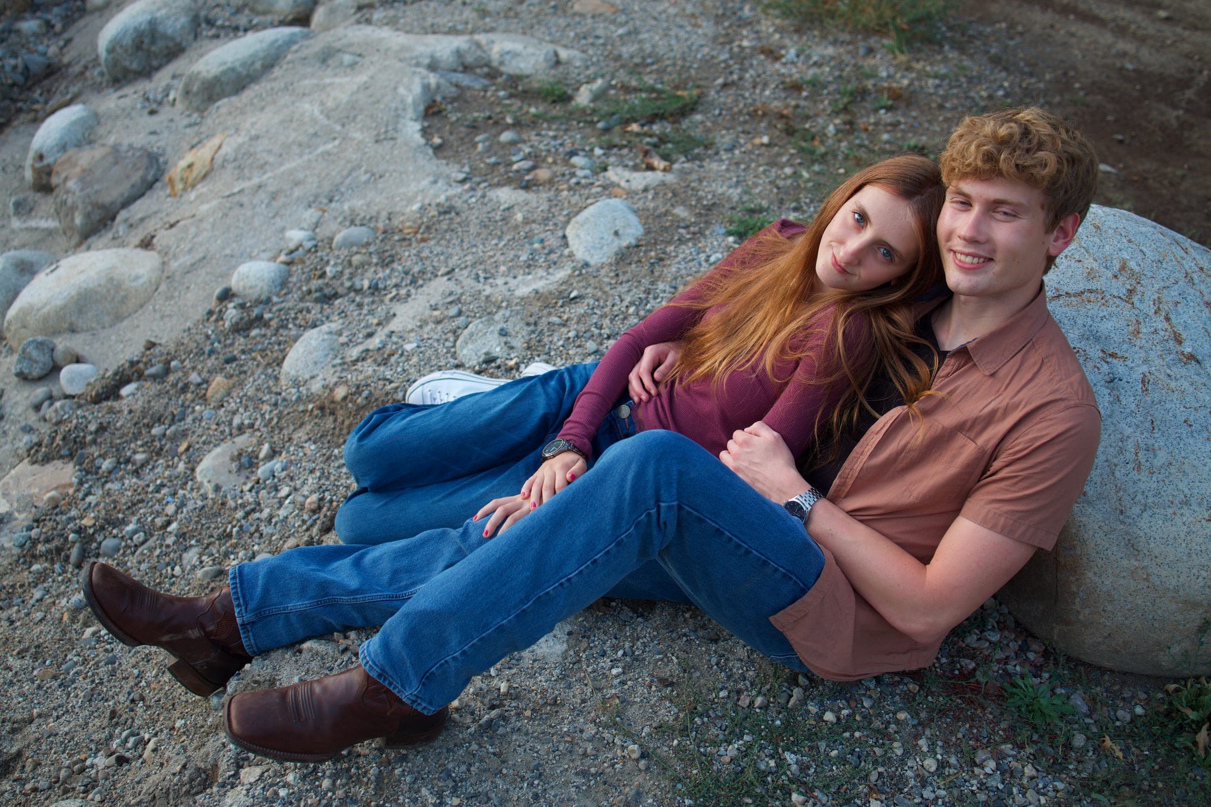 Molly and Tyler lounging against a boulder
