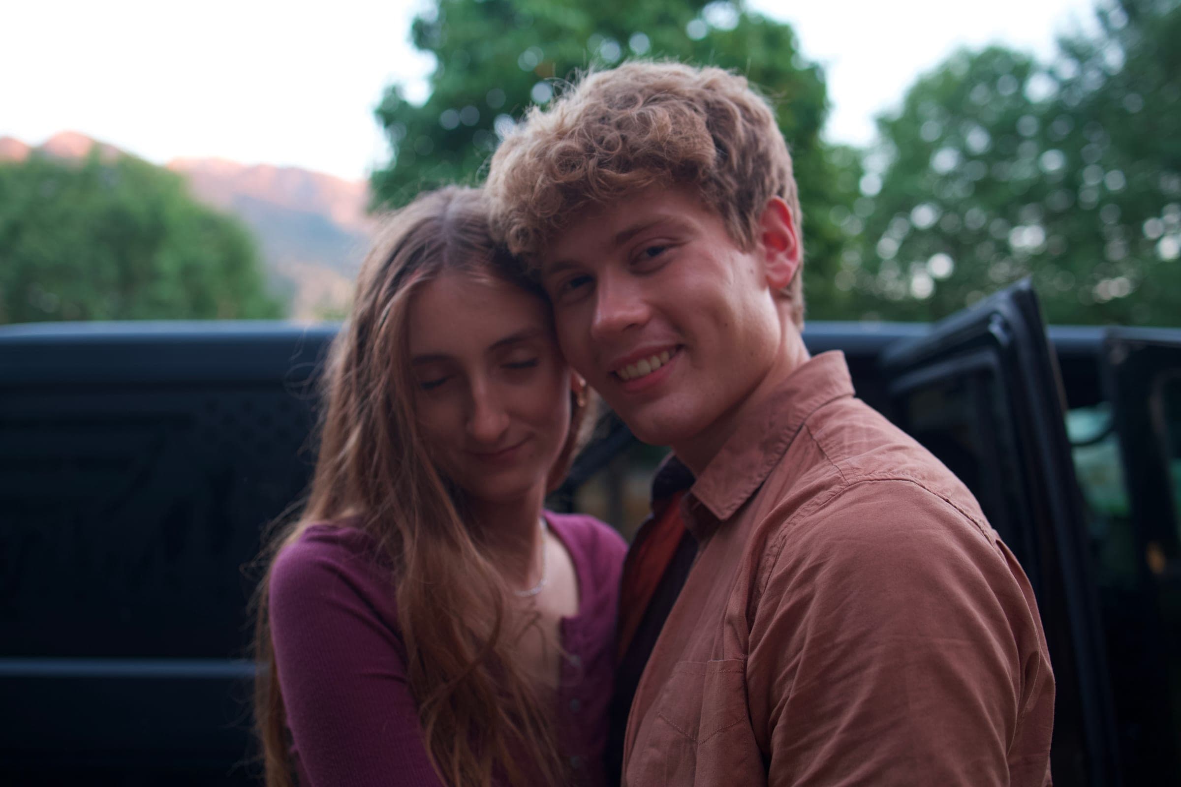Molly and Tyler cuddled up by the truck at dusk